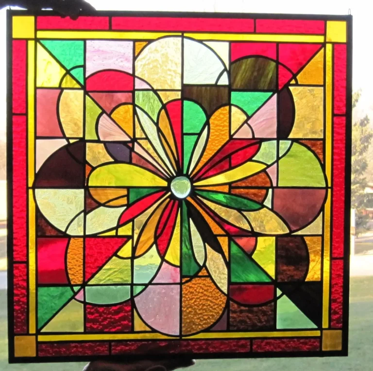 A square stained glass print featuring a central floral sunburst surrounded by colorful geometric squares and circles