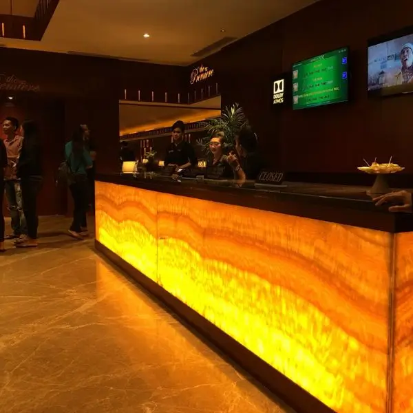 Modern reception interior design Dubai featuring a glowing honey-onyx backlit counter